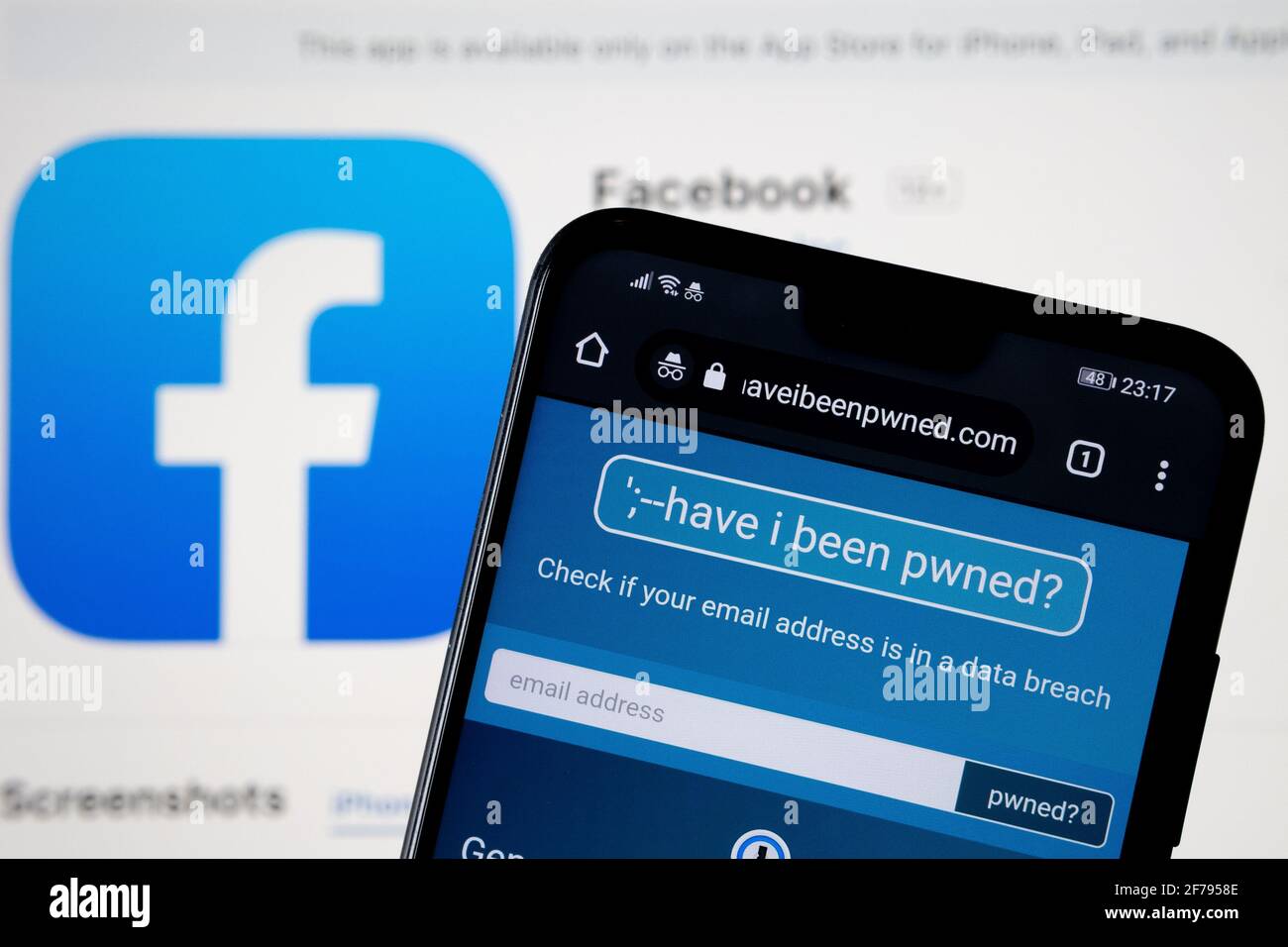 Web site 'Have I been pwned' seen on the smartphone with Facebook logo on the back. Service that check if your email and facebook account have been co Stock Photo