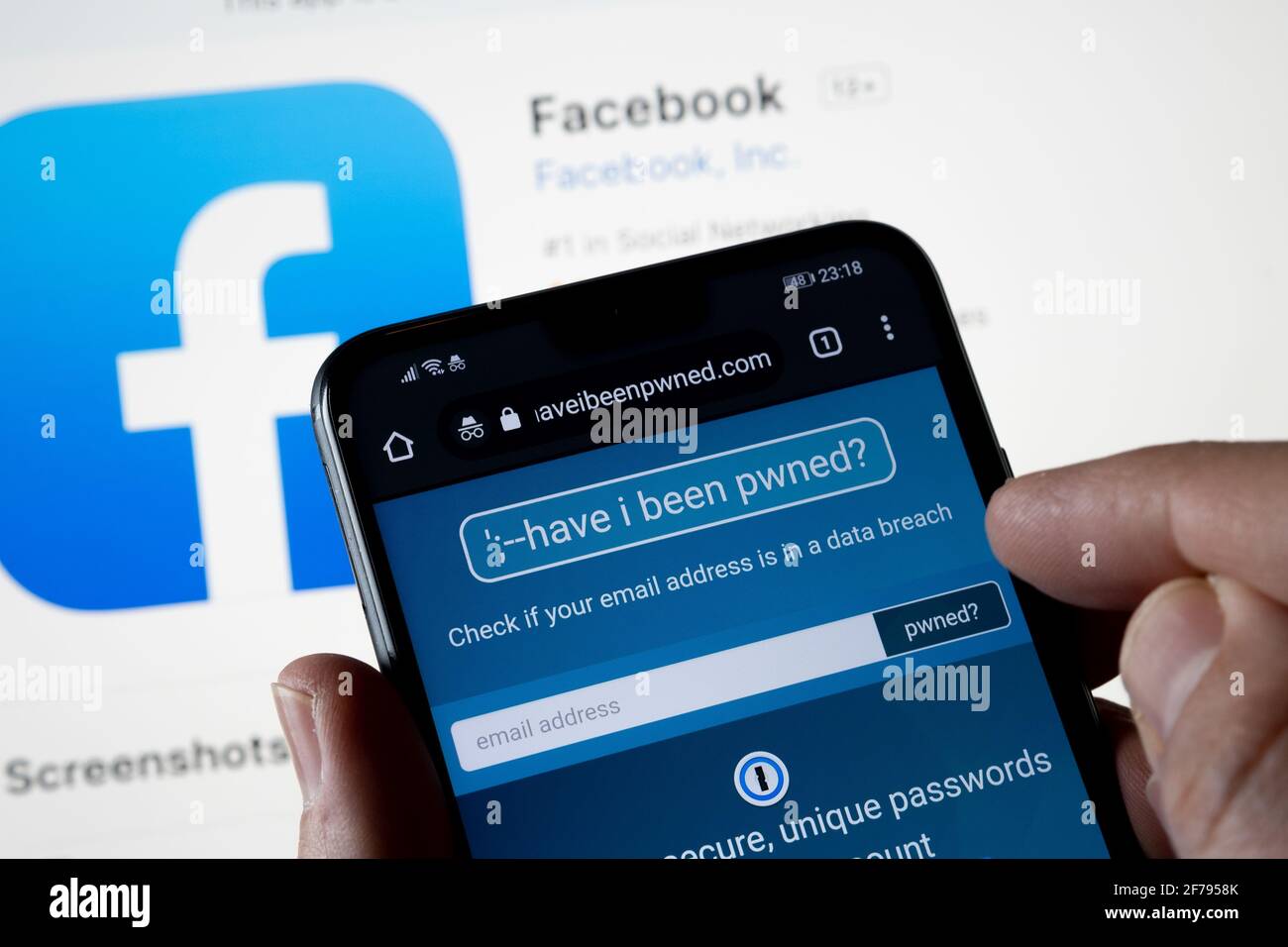 Web site 'Have I been pwned' seen on the smartphone with Facebook logo on the back. Service that check if your email and facebook account have been co Stock Photo