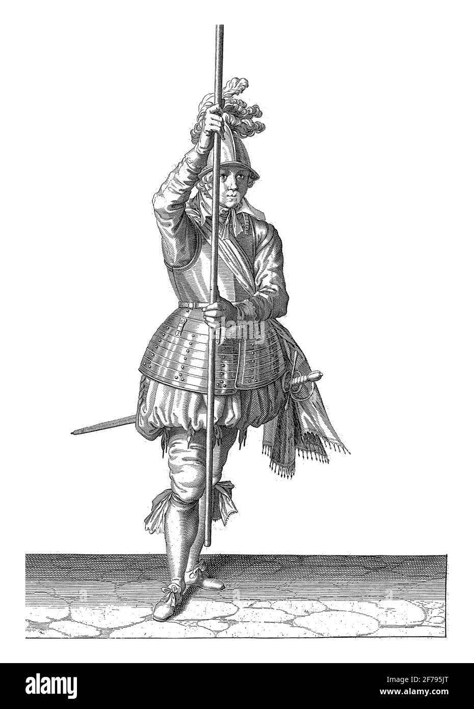 A full-length soldier holding a skewer (lance) with both hands upright in front of him slightly above the ground, This is the first act of lifting the Stock Photo