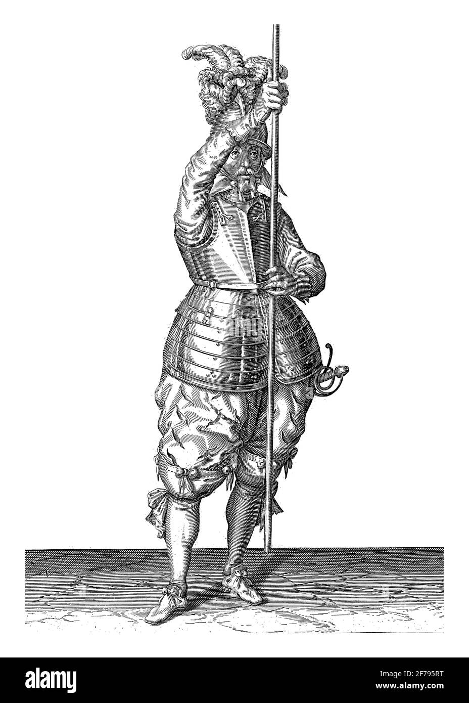 A full-length soldier holding a skewer (lance) with both hands upright in front of him slightly above the ground, this is the second act of placing th Stock Photo