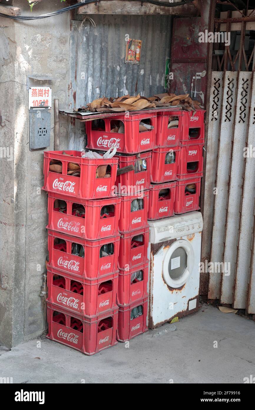 Stacked plastic Coca-cola crates, outside a closed shop at 105 Yin Kong Tsuen, North District, New Territories, Hong Kong, China 11th March 2021 Stock Photo