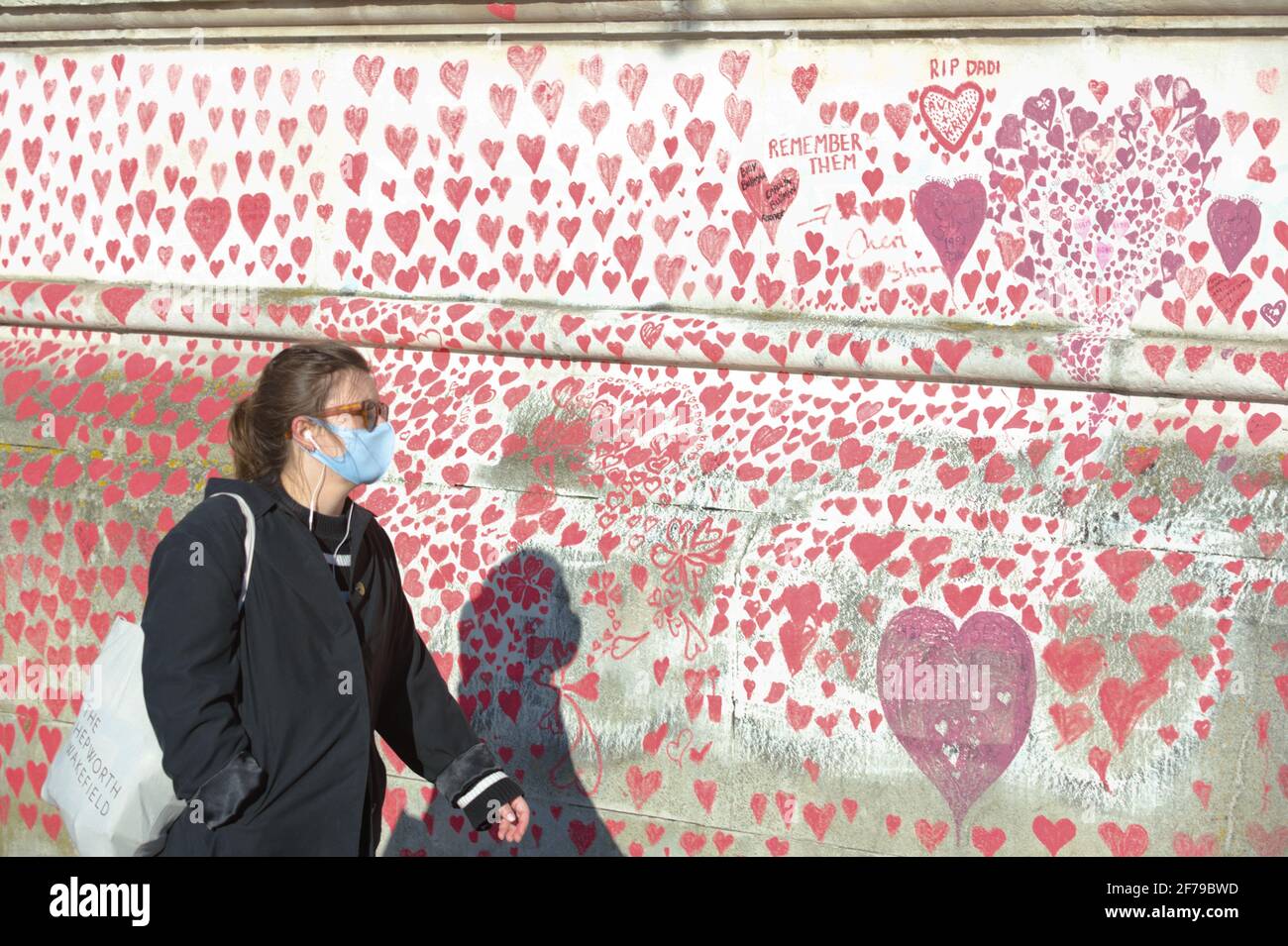 The national Covid Memorial Wall next to the Thames in London. Red hearts of been painted on the wall as a tribute to the victims of the virus. Stock Photo