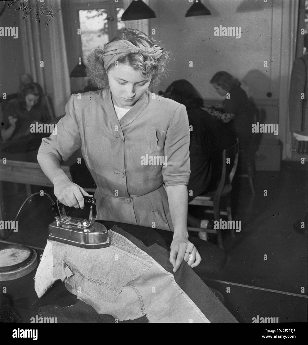 Light image regarding the youth prospects on the craft and industrial area. Woman stroking, seamstress. Stock Photo