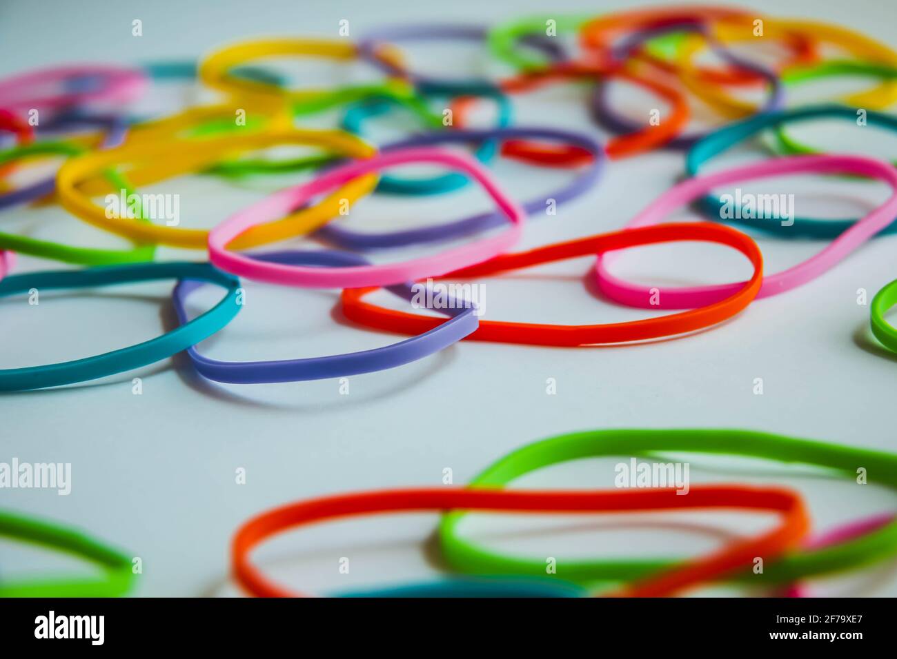 Side view of colorful rubber bands on white. Rainbow elastic rubber
