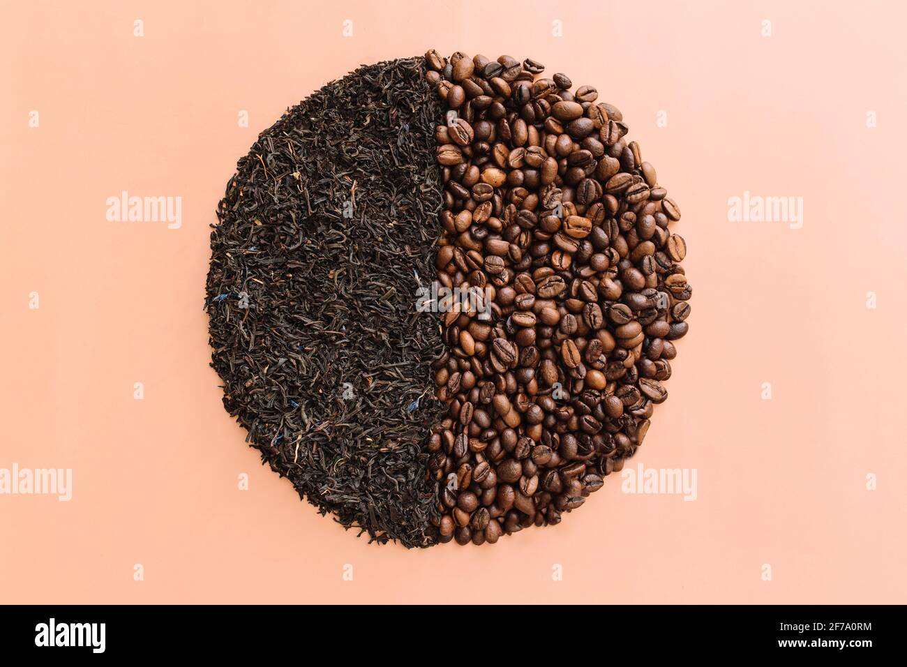 Beige flat lay background with circle with two halves, roasted coffee beans and dried tea leaves. Idea and composition, choice between coffee beans an Stock Photo
