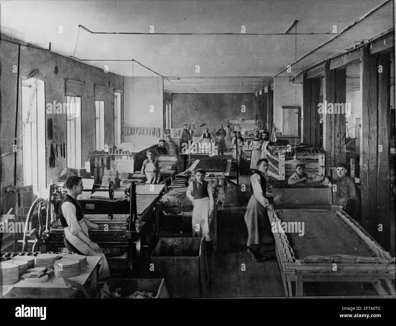 Cutting of rubber at rubber factory, around the turn of