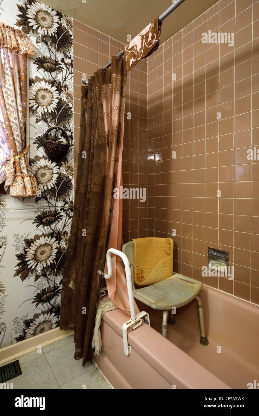 A retro bathroom with a , shower chair and a grab bar used by elderly people. Stock Photo