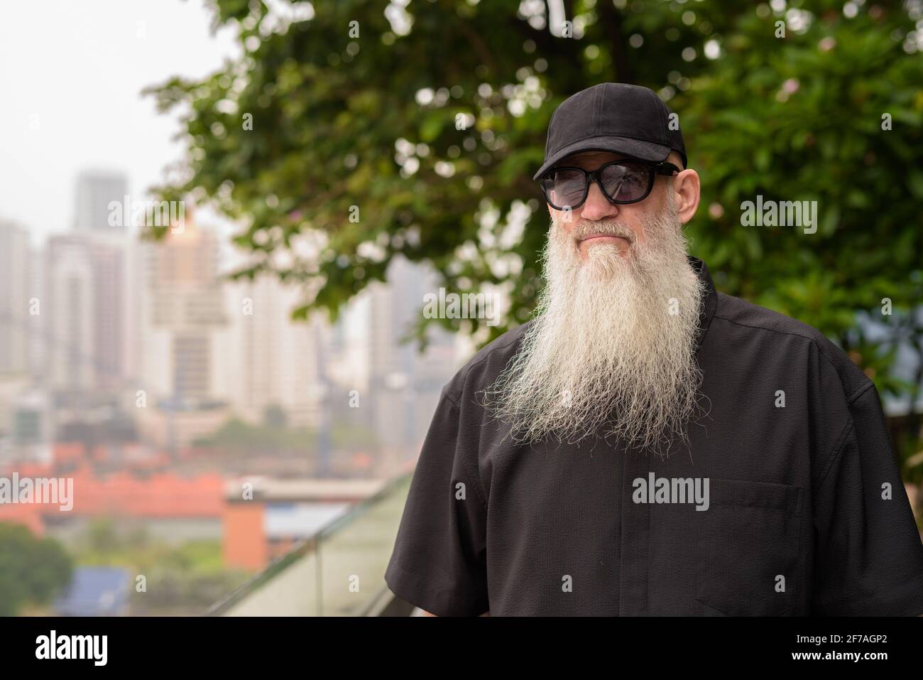 Portrait of man bald man with long gray beard thinking outdoors at rooftop garden Stock Photo