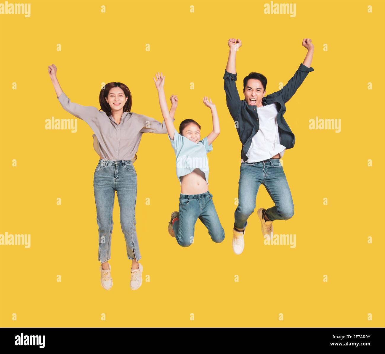 Happy young family with one child jumping together Stock Photo