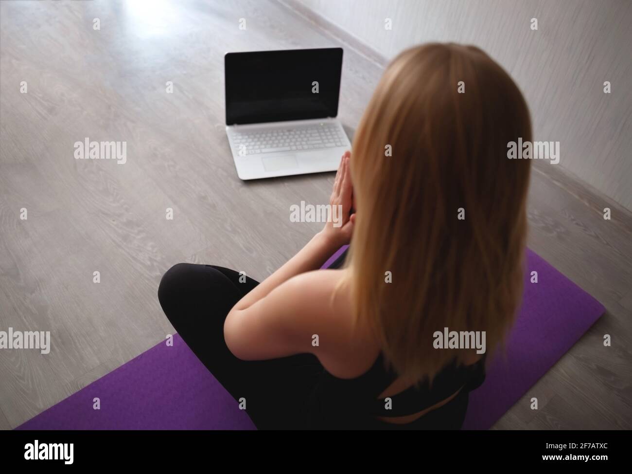 young woman doing asana at home on yoga mat in front of laptop Stock ...