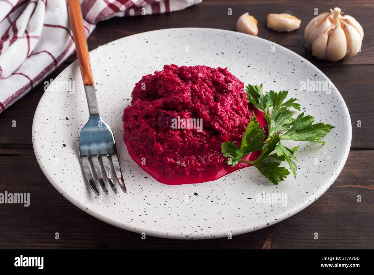 Salad of grated beetroot pine nuts and parsley with cream sauce on a plate Stock Photo