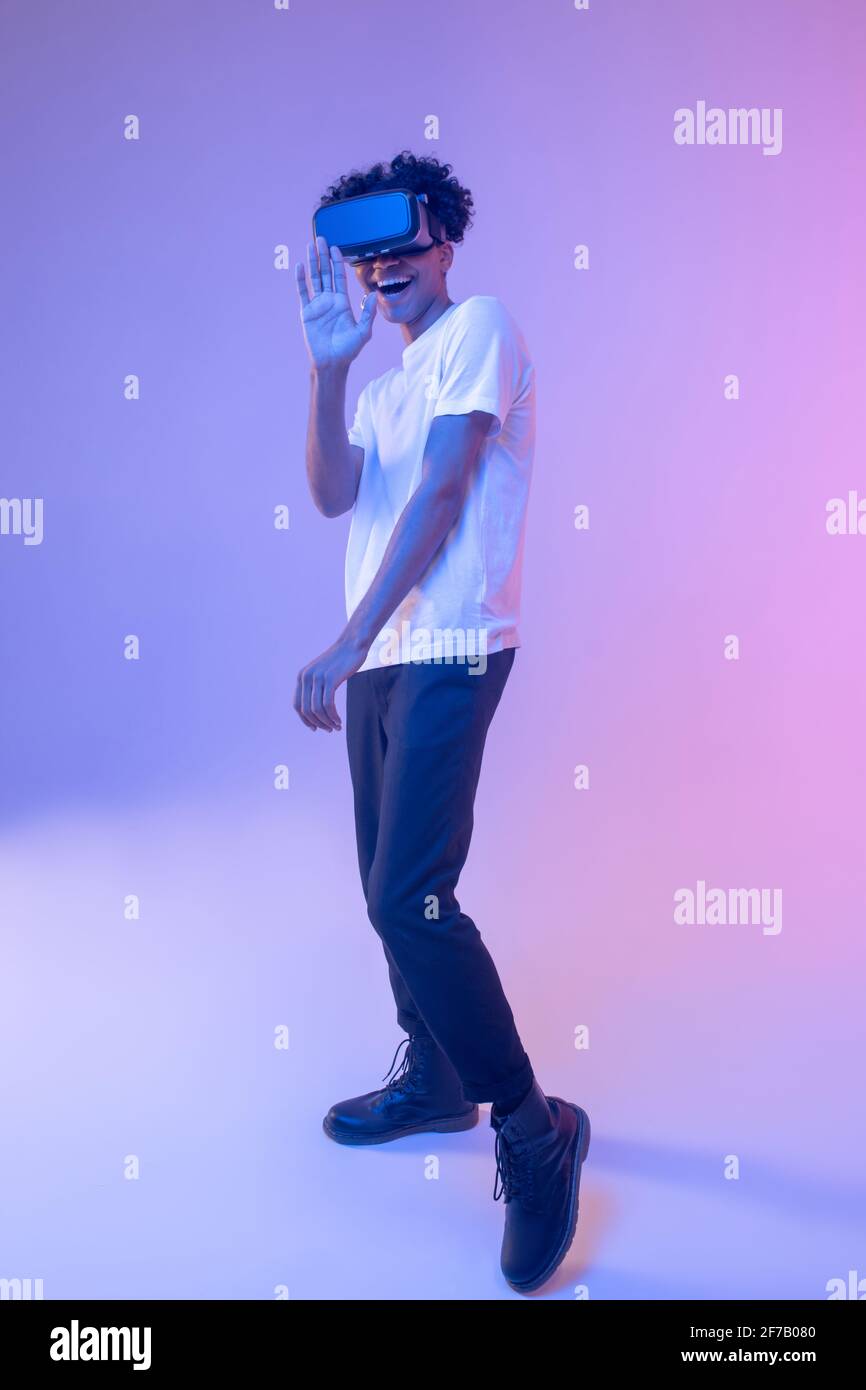 African american young guy wearing vr glasses and looking entertained ...