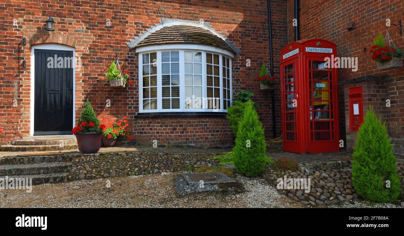 Old Post Office with Red Phone Box  housing defibrillator and Red Letter box. Stock Photo