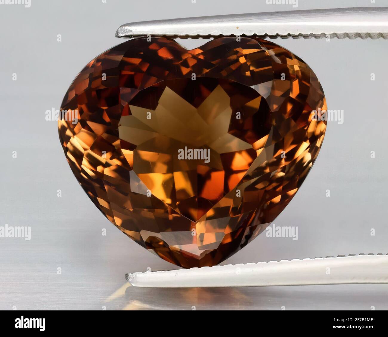 Natural gemstone orange imperial topaz on gray background Stock Photo