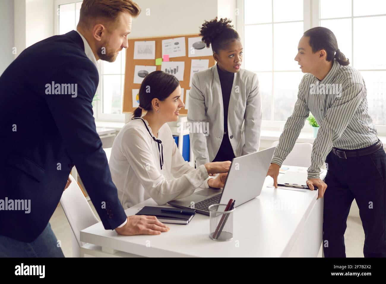 Group of multiracial business people discussing project, sharing ideas and using laptop Stock Photo