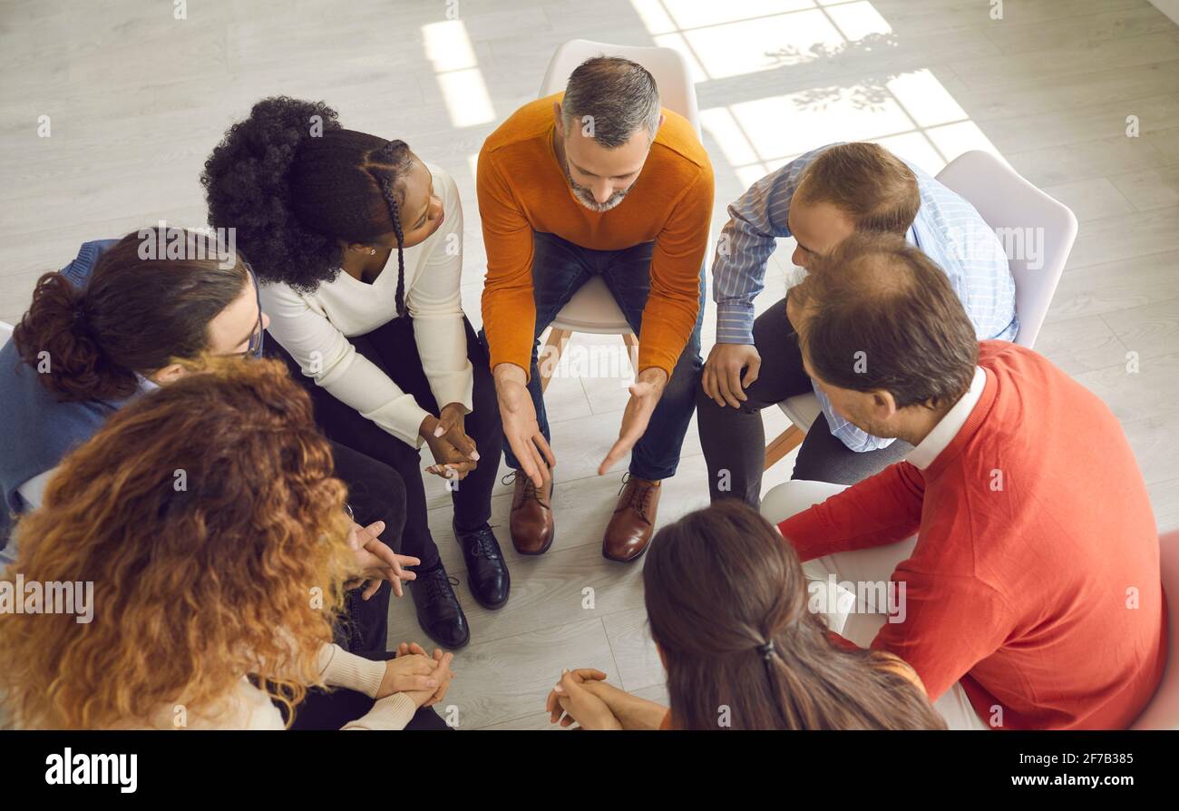 High angle shot of diverse group of people talking in therapy session or business meeting Stock Photo