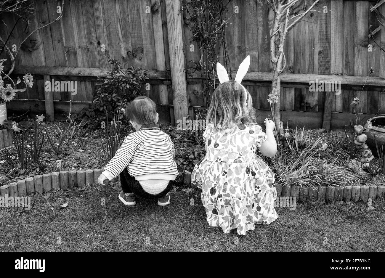 Easter 2021 with family 2 young children brother and sister playing in a garden Stock Photo