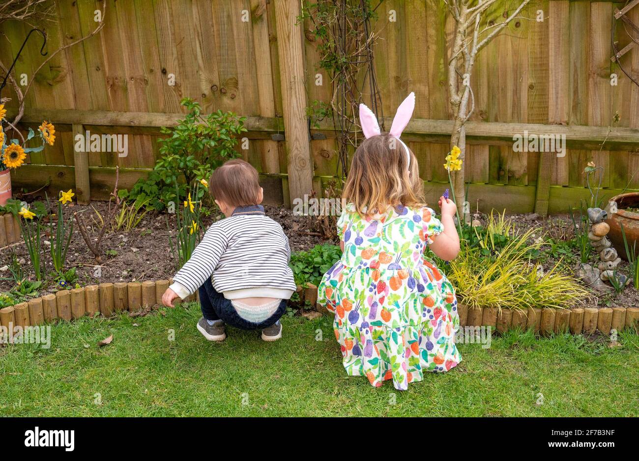 Easter 2021 with family 2 young children brother and sister playing in a garden Stock Photo