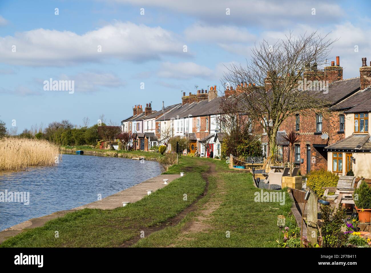Row of terrace houses seen on a bend of the the Leeds Liverpool Canal near Burscough, Lancashire in April 2021. Stock Photo
