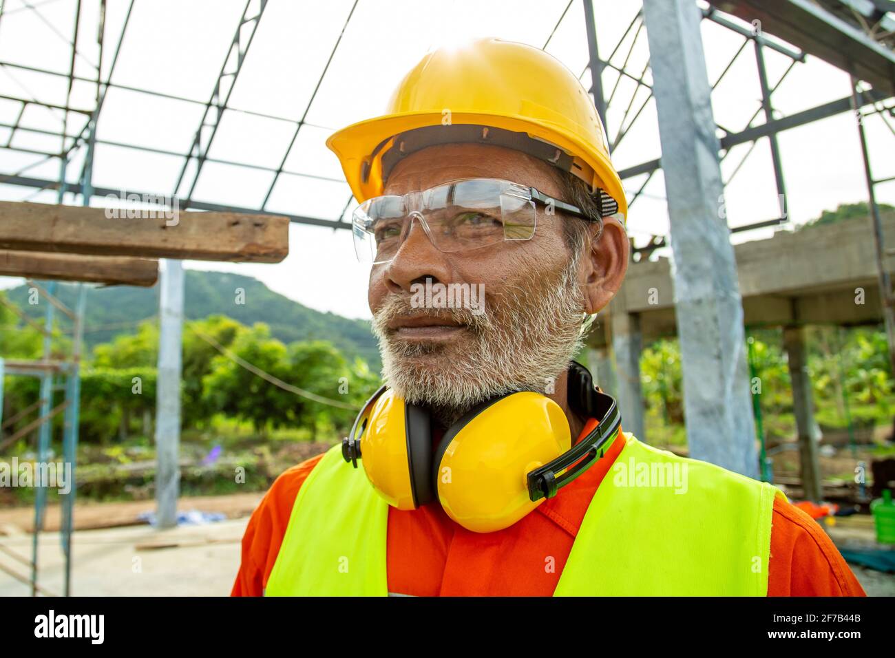 Portrait of Engineer technician senior worker in analyzing an Unfinished Construction Project. Stock Photo