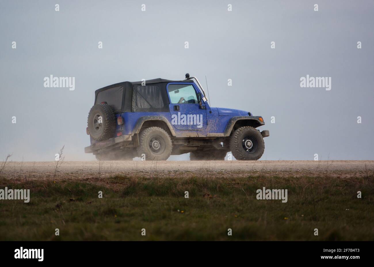 off road jeep vehicle creating clouds of dust on a stone track, Salisbury Plain Wiltshire Stock Photo