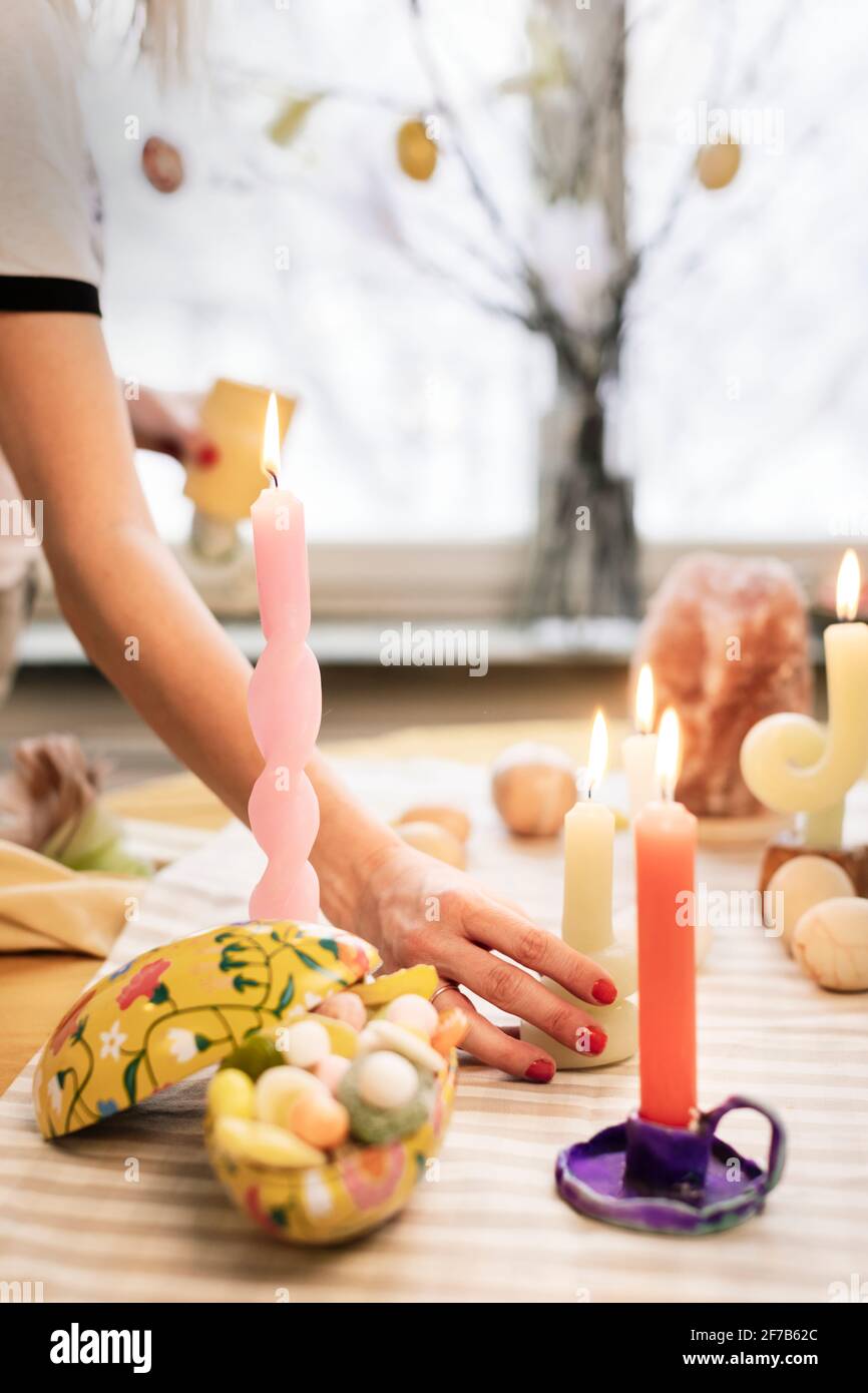 Woman putting candles on Easter table Stock Photo