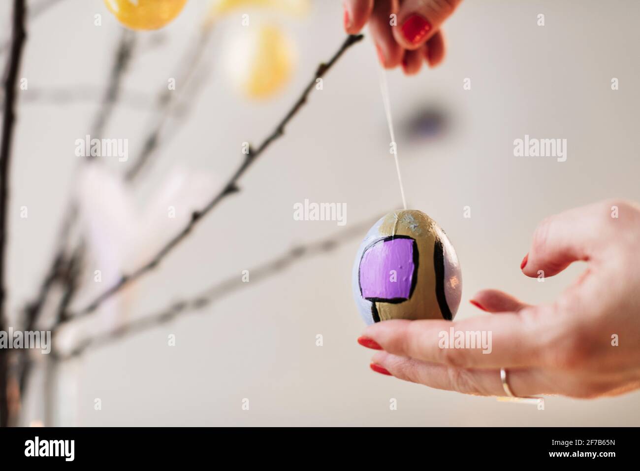 Woman's hands hanging Easter decoration Stock Photo