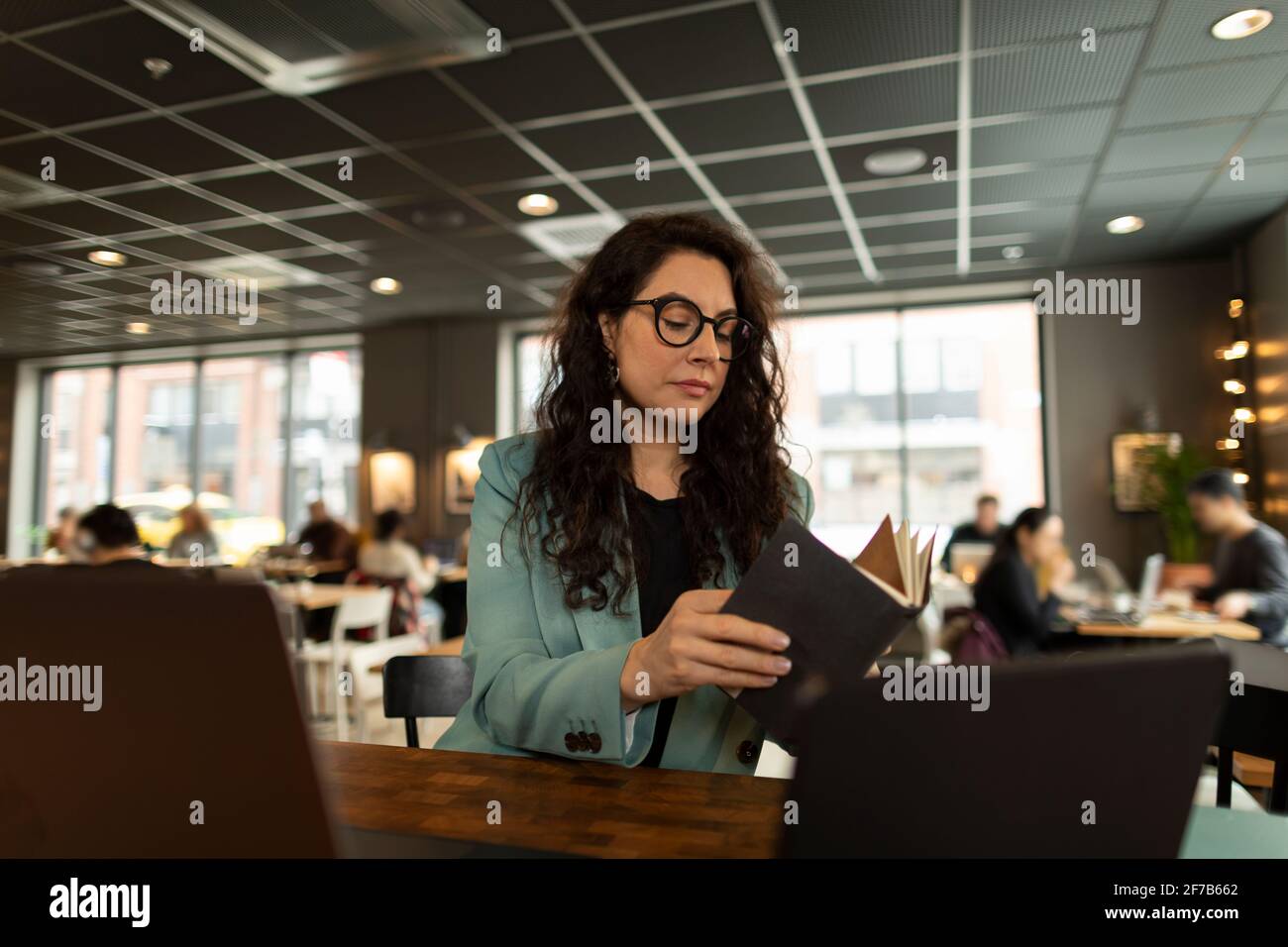 Businesswoman checking diary in cafe Stock Photo
