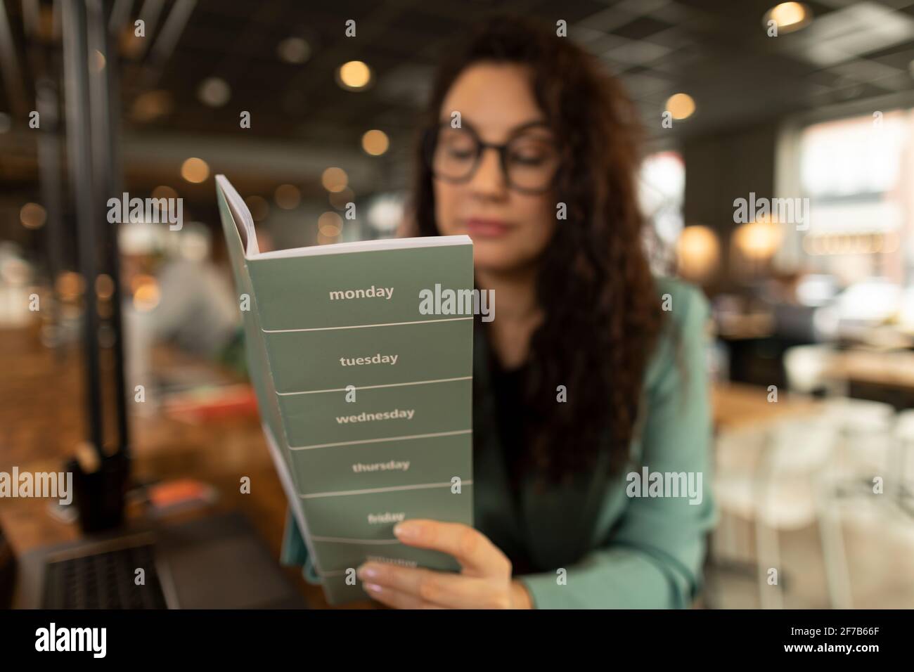 Businesswoman checking diary in cafe Stock Photo