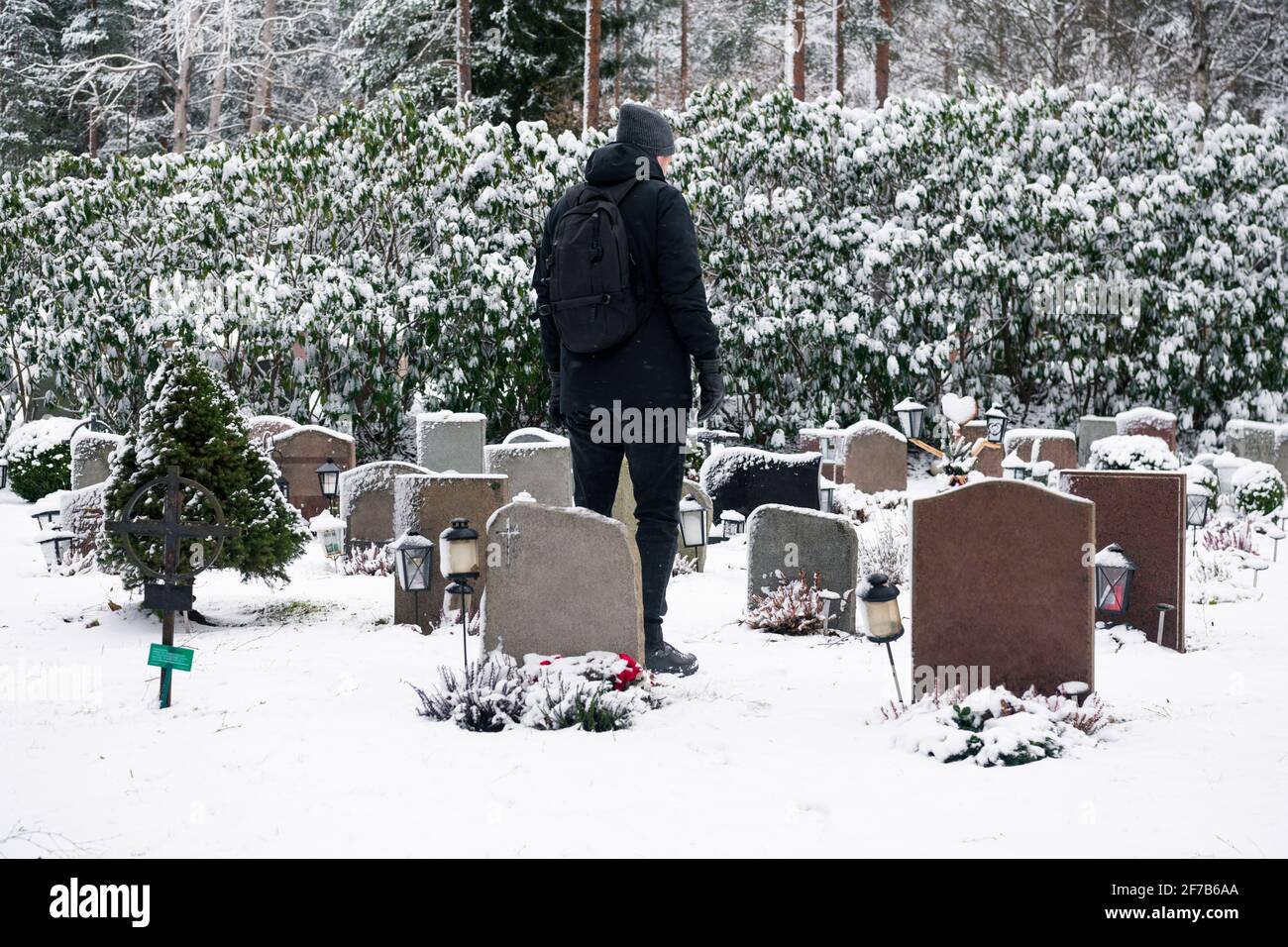 Man standing over grave at cemetery Stock Photo - Alamy