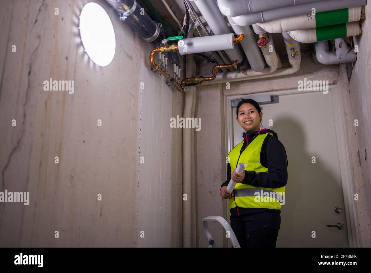Female plumber checking pipes Stock Photo