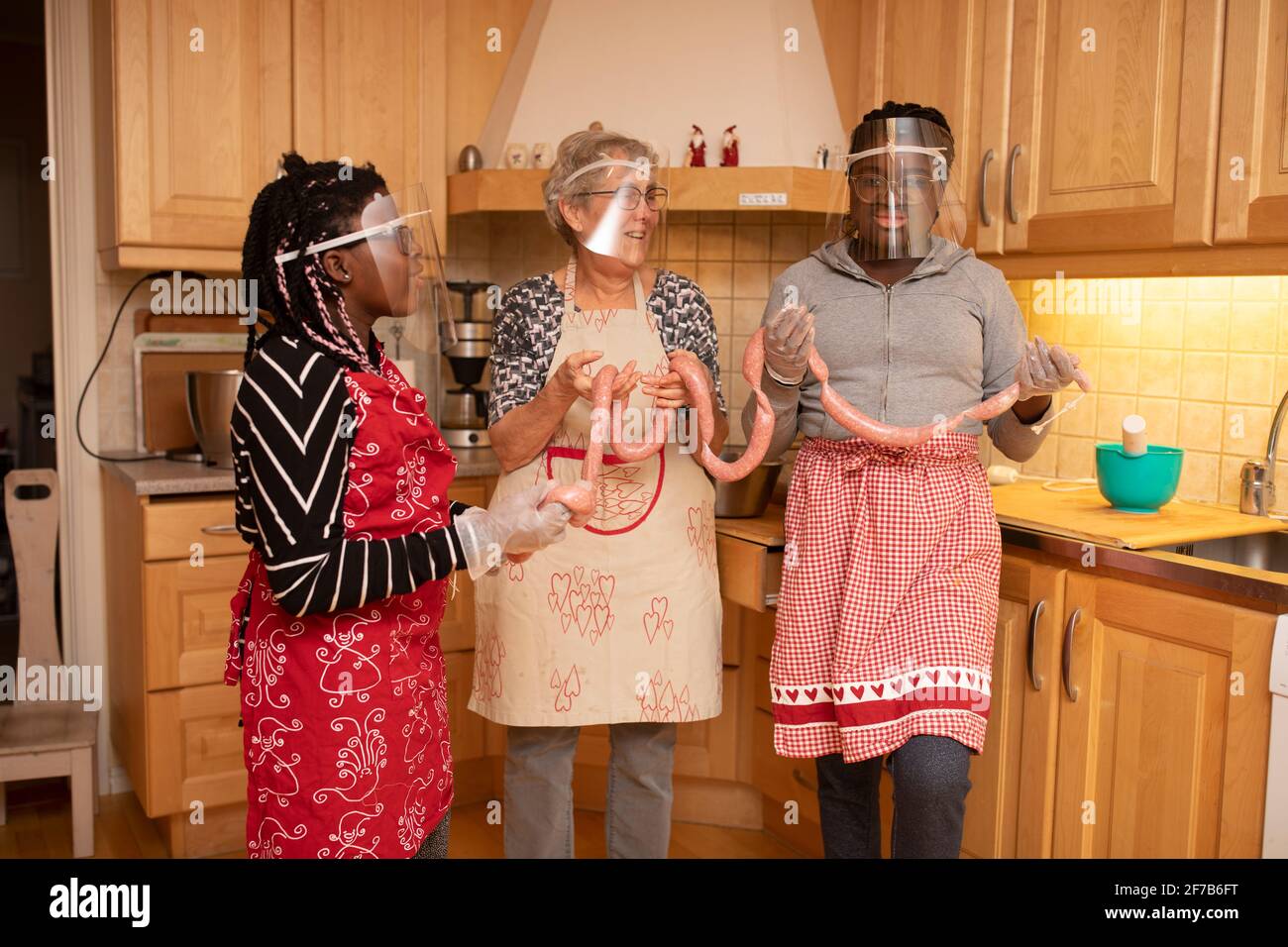 Women preparing sausages in kitchen Stock Photo