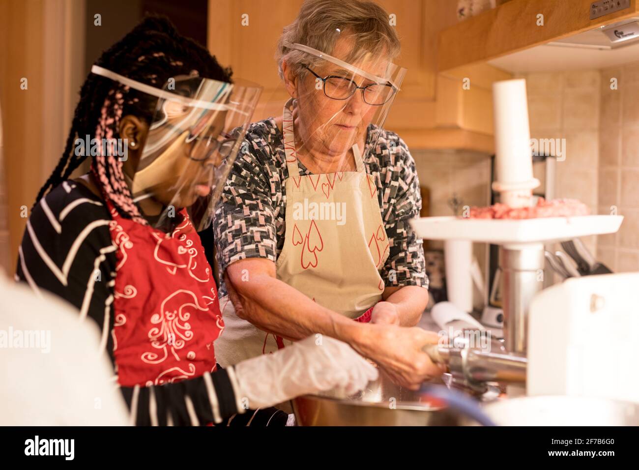 Women preparing sausages in kitchen Stock Photo