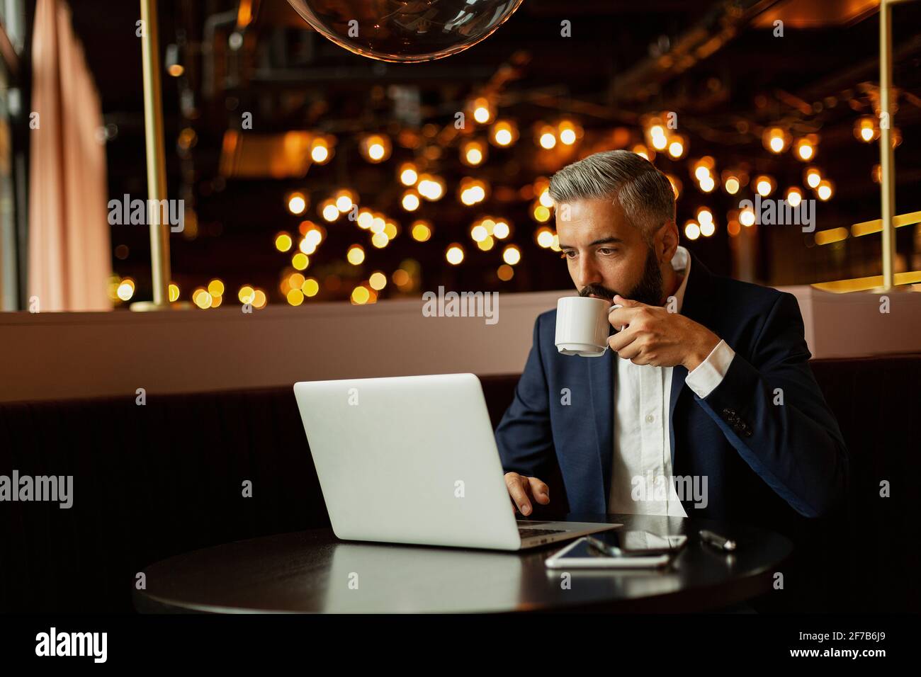 Businessman using laptop in cafe Stock Photo