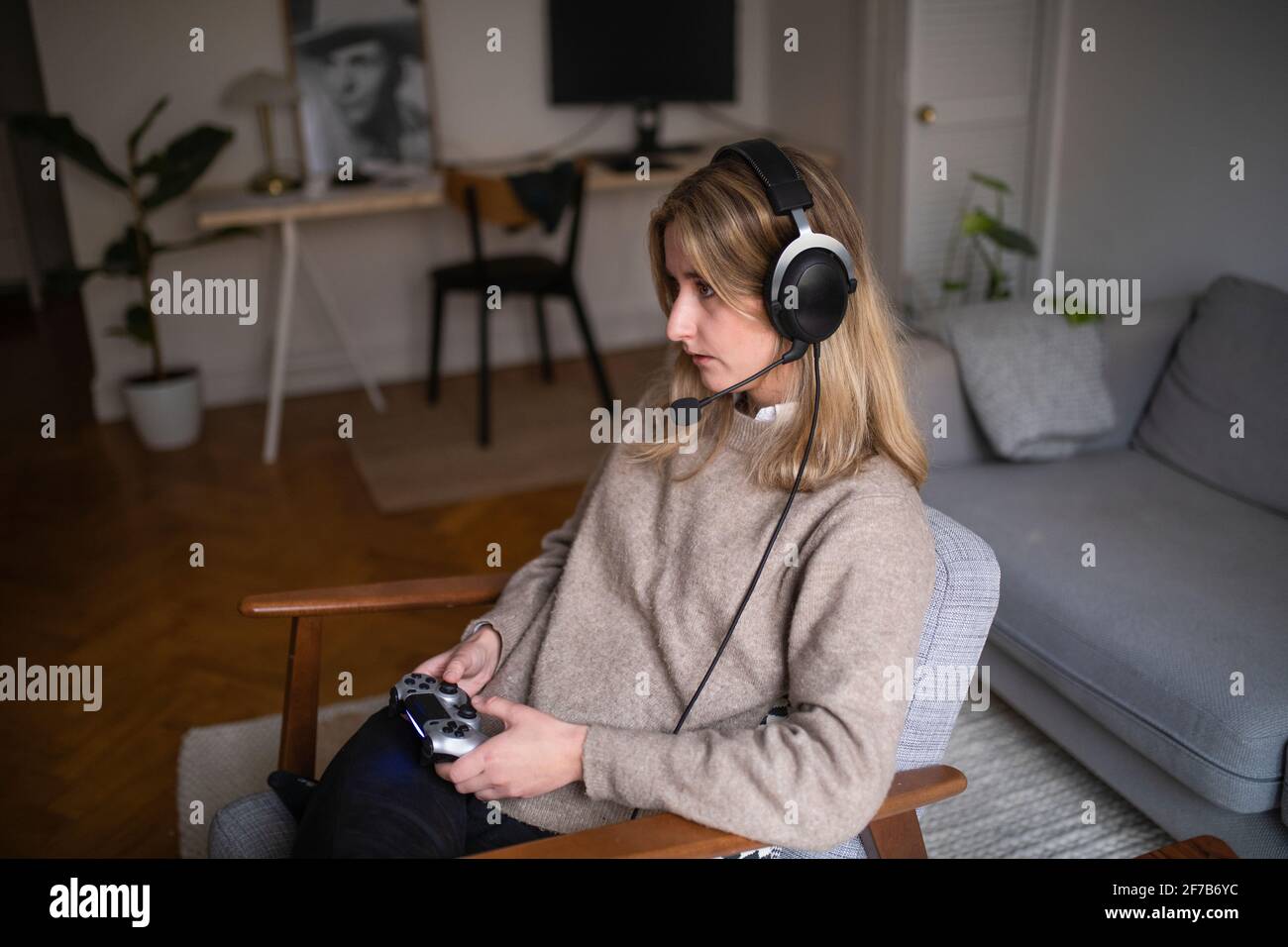 Young woman with headset playing video game Stock Photo