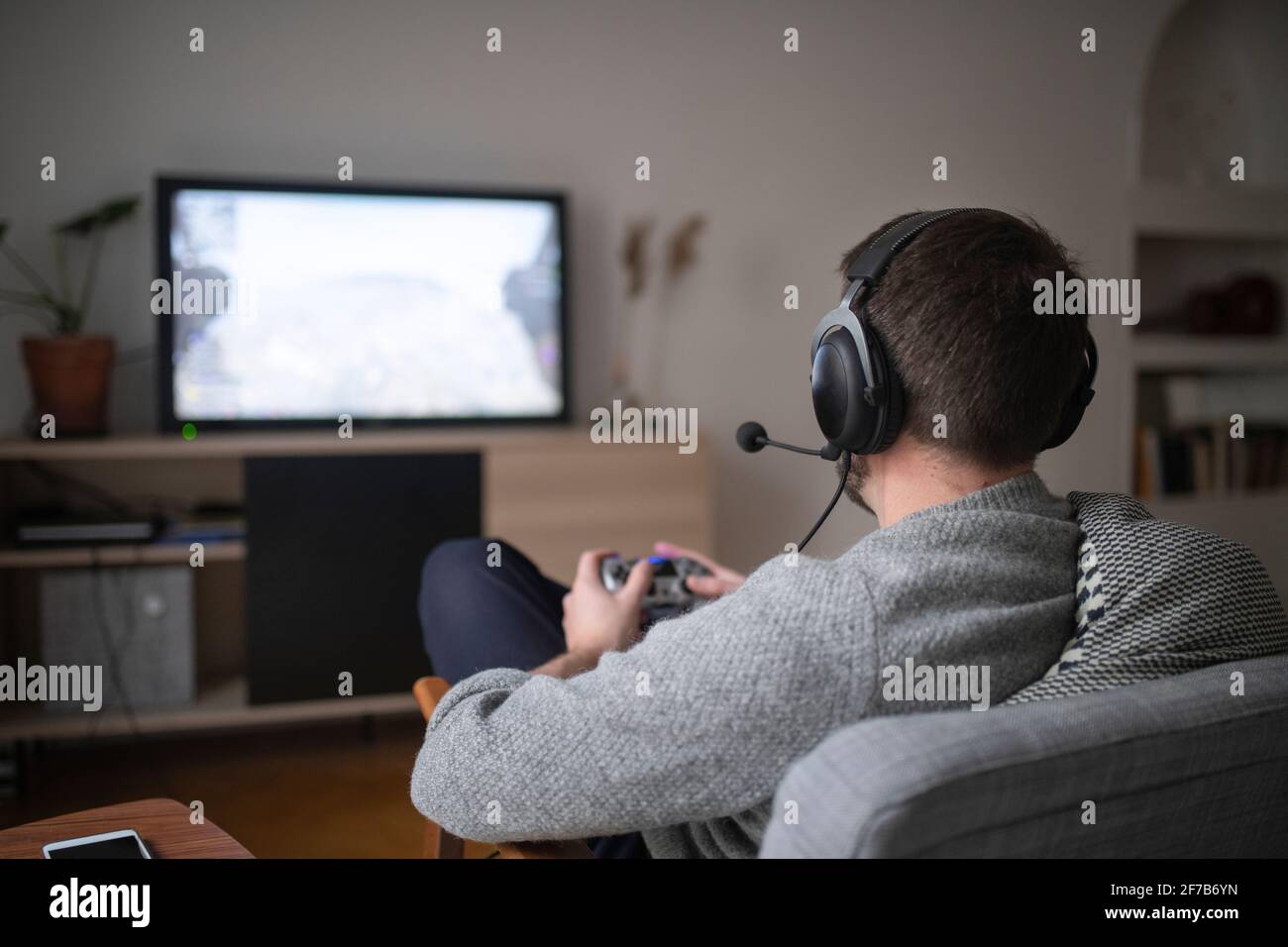 Man with headset playing video game Stock Photo