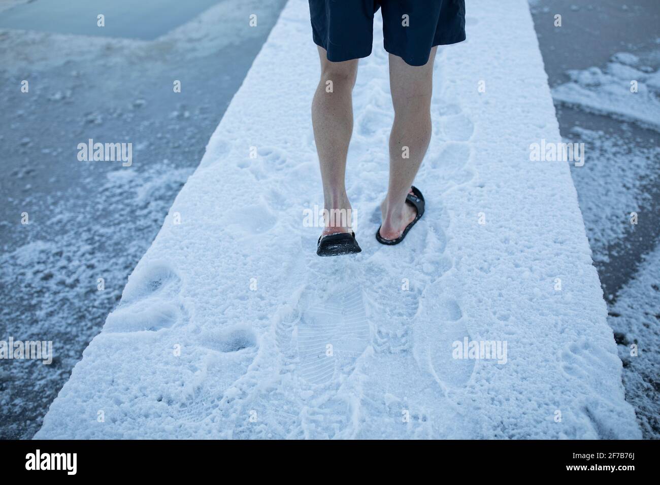 Low section of wan walking at frozen lake Stock Photo