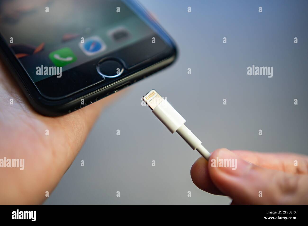 Bangkok, Thailand - April 2, 2021 : Charging iPhone 7 with lightning cable. Stock Photo