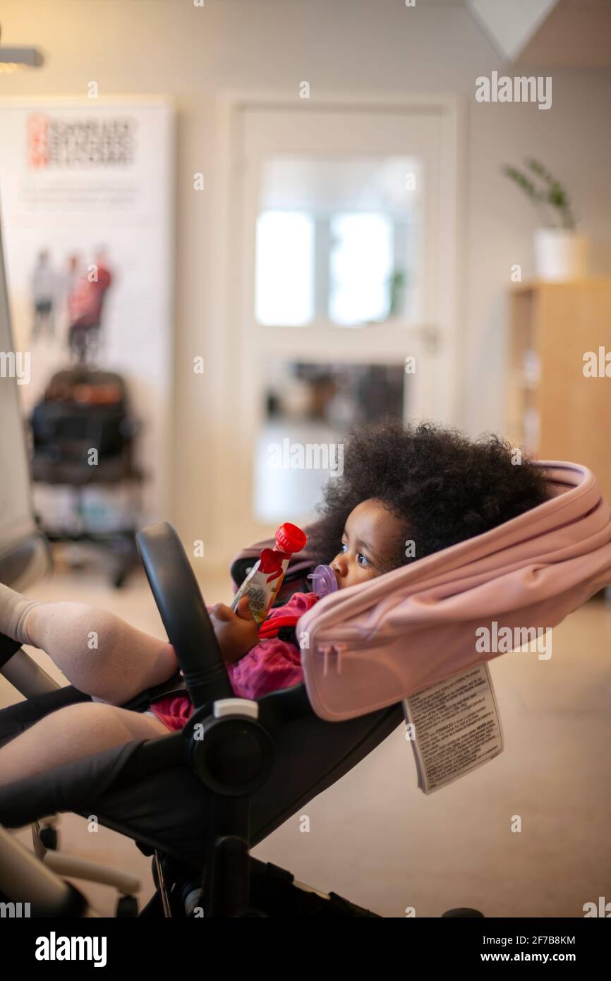 Girl sitting in baby carrier Stock Photo