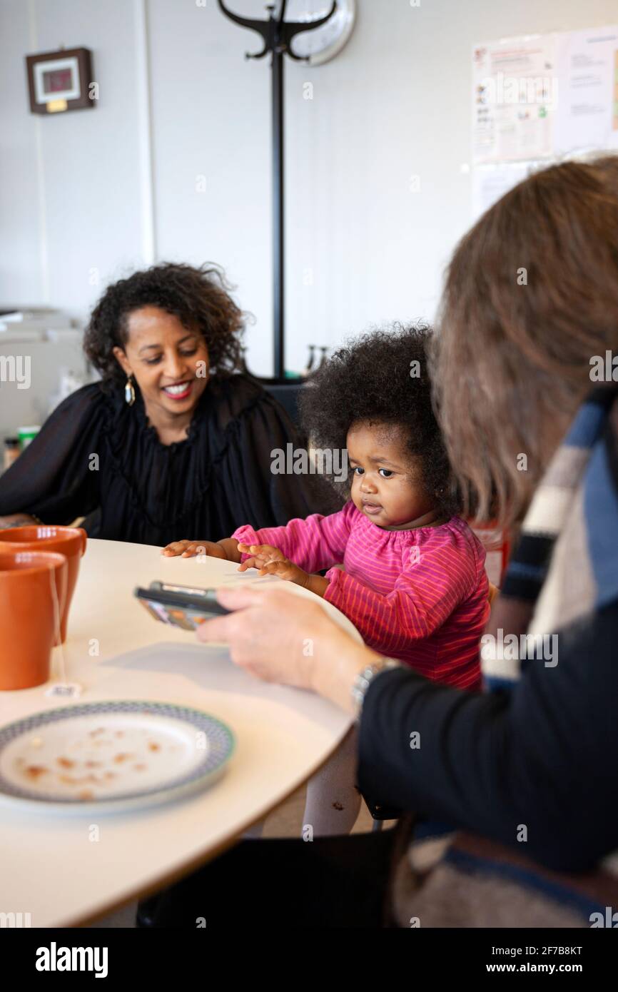Mother with daughter in office talking to colleague Stock Photo