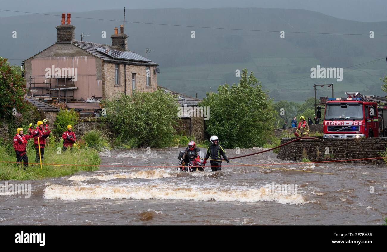 Motorcyclist being rescued from a flooded river at Gayle, Hawes in North Yorkshire, by fire service and Swaledale Mountain Rescue crews. North Yorkshi Stock Photo