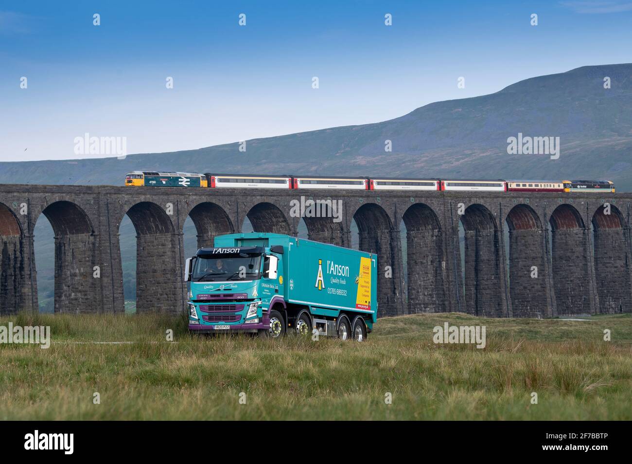 Livestock feed company wagon making delivery to a farm alongside the