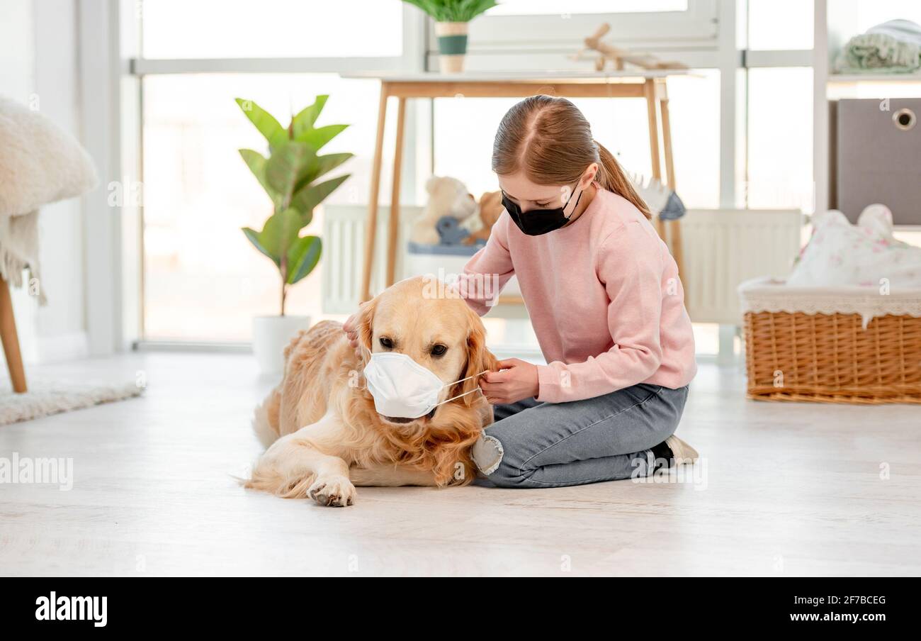 Little girl in mask with golden retriever dog Stock Photo - Alamy