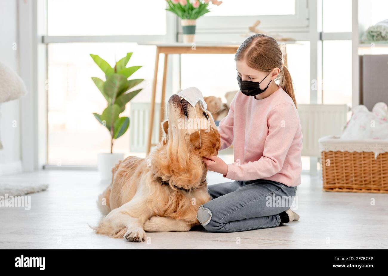 Little girl in mask with golden retriever dog Stock Photo - Alamy