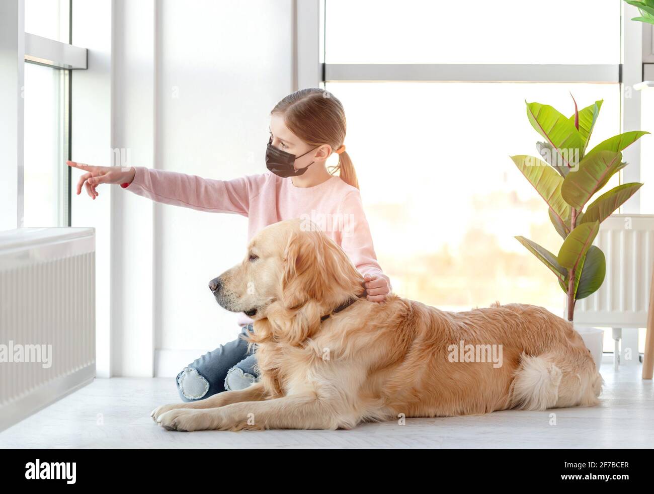 Little girl in mask with golden retriever dog Stock Photo - Alamy