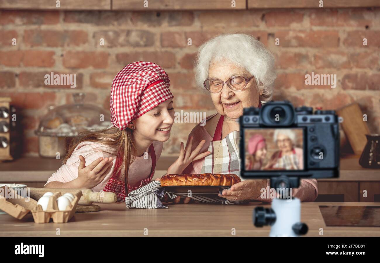 Little granddaughter with granny enjoying homemade fruit pie Stock Photo