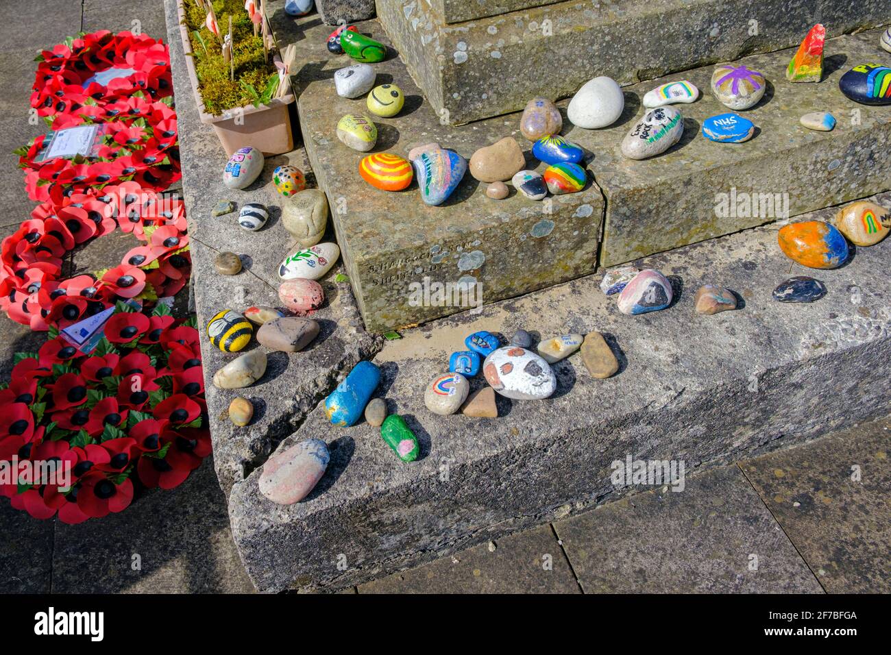 Painted pebbles decorating a war memorial during the Covid-19 pandemic, Taddington, Peak District National Park, Derbyshire Stock Photo