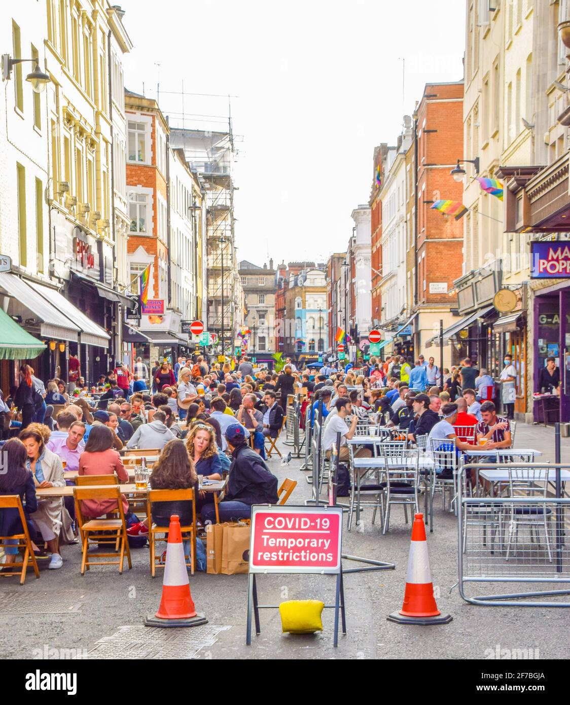 Crowd of people in Old Compton Street, Soho. Temporary al fresco street seating was implemented to allow bars and restaurants to operate and facilitate social distancing during the coronavirus pandemic. London, United Kingdom, 21st August 2020. Stock Photo