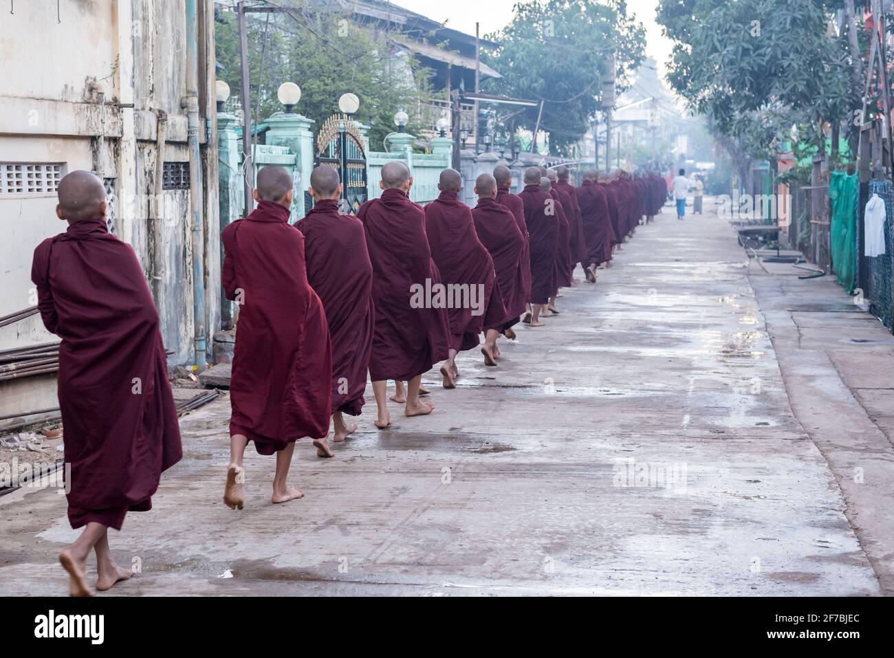 Monks walking in the streets of Bago collecting food donations, Bago, Myanmar Stock Photo