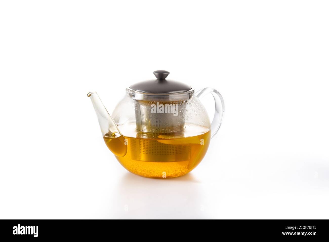 Teapot with ginger tea, lemon and honey isolated on white background